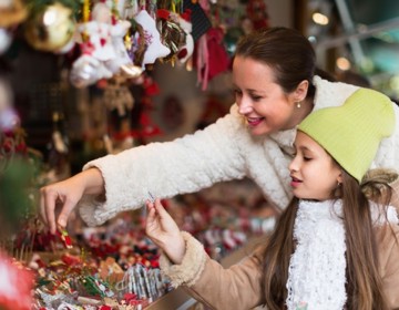 Moeder en dochter bekijken spulletjes bij kerststalletje